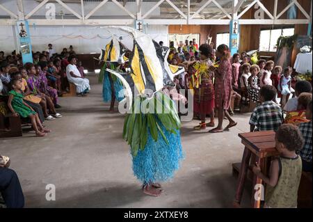 PAPOUASIE-NOUVELLE-GUINÉE, Madang, village Riwo, messe dans l'église catholique, danse traditionnelle avec des poissons comme costume pendant la messe / PAPUA NEUGUINEA, Madang, Dorf Riwo, katholische Kirche, Messe am Sonntag, traditioneller Tanz während der Messe, Junge im Fisch Kostüm Banque D'Images