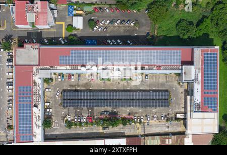 Parking et bâtiment sur le toit couvert de panneaux solaires au-dessus de la vue du drone supérieur Banque D'Images