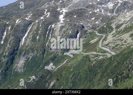 Vue de la route de montagne escarpée sur la pente au-dessus de la ligne des arbres avec virages en épingle à cheveux ascension vers Grimsel Pass, Alpes, Canton Valais, Suisse, Europe Banque D'Images