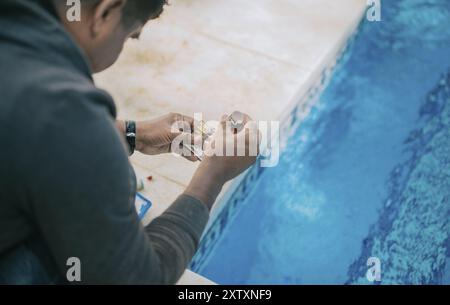 Kit testeur pour mesurer le chlore et le ph dans les piscines. Personne testant le pH de la piscine Banque D'Images