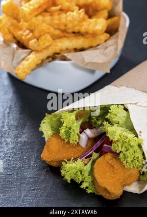 Wrap avec des morceaux de poulet frit et une portion de frites Banque D'Images