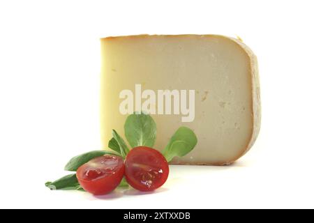 Morceau de fromage avec tomates et laitue d'agneau sur fond blanc Banque D'Images