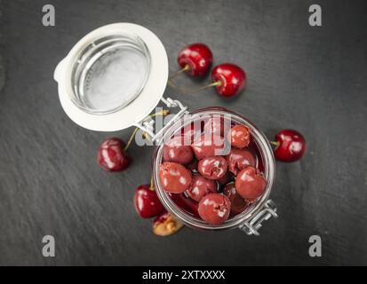 Portion de cerises conservées en gros plan détaillé sur une dalle d'ardoise, mise au point sélective Banque D'Images