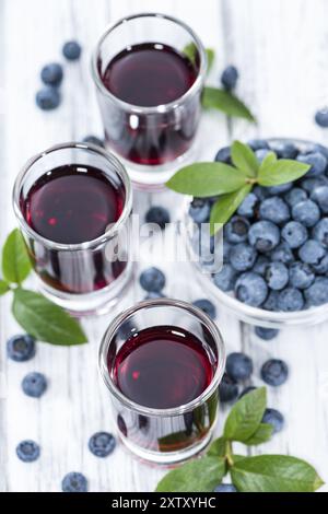 Liqueur de myrtille avec quelques fruits dans un petit verre Banque D'Images