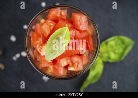 Partie de tomates coupées en gros plan détaillé sur une dalle d'ardoise (selective focus) Banque D'Images