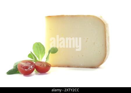 Morceau de fromage avec tomates et laitue d'agneau sur fond blanc Banque D'Images