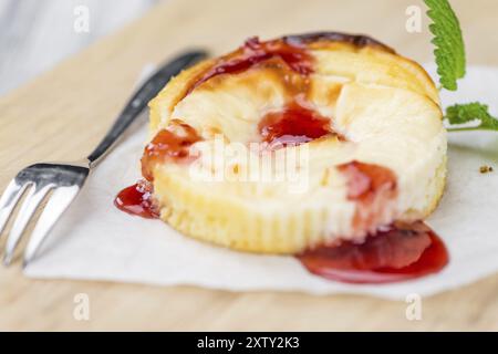 Mini Cheesecake (avec la sauce) comme haut Gros plan détaillé sur une table en bois vintage (selective focus) Banque D'Images