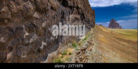 Digue basaltique menant au bouchon volcanique appelé Shiprock. NM Shiprock est composé de brèches volcaniques fracturées et de digues noires d'appel rocheux igné Banque D'Images