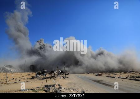 Gaza. 16 août 2024. De la fumée s'élève à proximité de la zone des tours Hamad au Nord-Ouest de la ville de Khan Younis, dans le sud de la bande de Gaza, le 16 août 2024. Les habitants de la bande de Gaza restent pris au piège d'un cauchemar sans fin de morts et de destructions, alors que de nouveaux ordres d'évacuation ont été émis par les autorités israéliennes, a déclaré vendredi l'agence des Nations Unies pour les réfugiés palestiniens. Crédit : Rizek Abdeljawad/Xinhua/Alamy Live News Banque D'Images