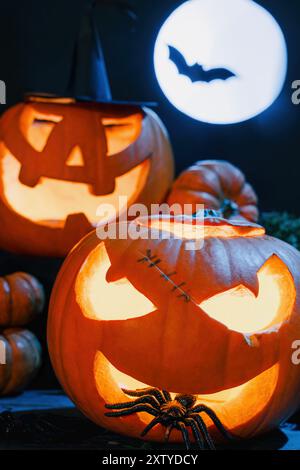 Araignée sortent de la bouche de Halloween sculptée Spooky Pumpkin, fond de nuit sombre avec pleine lune Banque D'Images