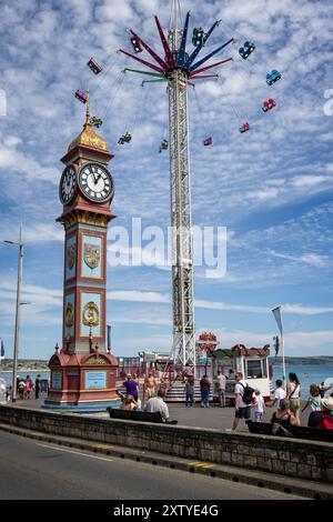 Jubilee Clock and Sky Carrousel amusement ride sur Weymouth Esplanade, Weymouth, Dorset, Royaume-Uni le 16 août 2024 Banque D'Images