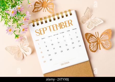 Septembre 2024 calendrier de bureau et papillon en papier avec fleur sur beau fond. Banque D'Images