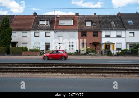 Brême, Allemagne, 16 juillet 2024 - Workman maisons en rangée avec des voies de tramway et une voiture rouge Banque D'Images