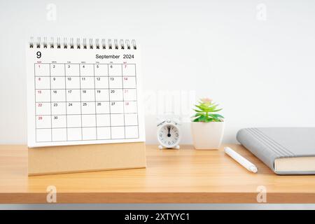 Septembre 2024, calendrier mensuel de bureau pour 2024 année sur la table en bois avec journal. Banque D'Images