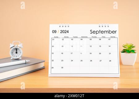 Septembre 2024, calendrier mensuel de bureau pour 2024 année sur la table en bois avec journal. Banque D'Images