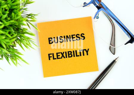 Symbole de flexibilité d'entreprise. Mots conceptuels flexibilité professionnelle. Concept de flexibilité d'affaires sur un autocollant de fleur de moutarde jaune sur un fond blanc Banque D'Images