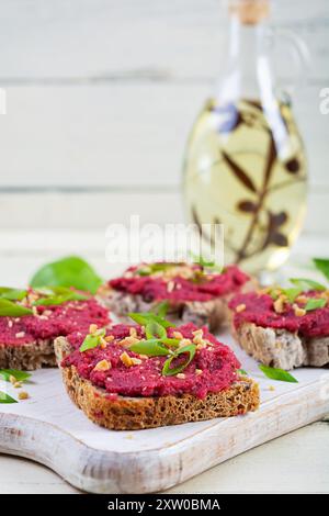 Toasts à la betterave, noix hachées et herbes. Bruschetta végétalienne à la betterave Banque D'Images