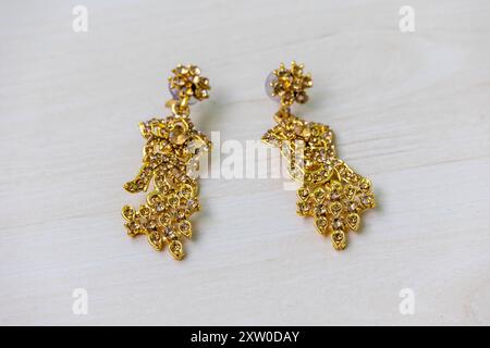 Belles boucles d'oreilles antiques sur la surface en bois. Boucles d'oreilles sont un type de bijoux porté sur les oreilles. Banque D'Images