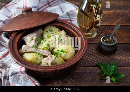 Ragoût de pommes de terre avec de la viande, des oignons et des herbes dans une cruche Banque D'Images