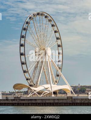 Bakou, Azerbaïdjan - 4 mai 2024 : la grande roue Baku Eye s'élève bien en vue sur le front de mer, offrant une vue imprenable sur la ville sous un ciel bleu vif Banque D'Images