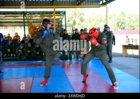 Armée combative. Deux combattants combattant dans un ring, regardant les arbitres. Un combat d'exposition entre hommes, instructeur officier et soldat stagiaire, amateurs. Banque D'Images