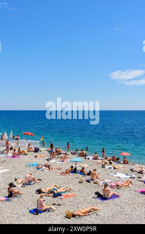 Les gens sur une plage de galets le long du front de mer de Nice, Nice, Provence-Alpes-Côte d'Azur, Alpes-Maritimes, France Banque D'Images