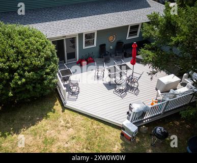 Vue drone donnant sur une terrasse à l'arrière d'une maison avec des meubles mis en place pour la détente. Banque D'Images