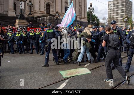 Melbourne, Australie. 17 août 2024. Affrontements entre policiers et contre-manifestants dans la rue lors d'une contre-manifestation et d'une contre-manifestation anti-trans. Les étapes du Parlement de l'État victorien ont été témoins d'une collision d'idéologies alors que les manifestants anti-trans réclament une plate-forme tandis que les militants de gauche trient pour les noyer dans le bruit et la musique. La présence de la police a intensifié le sentiment et il y a eu des cours, la police gardant les groupes séparés. La police montée a été utilisée pour repousser les manifestants Pro-TRANS. (Photo de Michael Currie/SOPA images/SIPA USA) crédit : SIPA USA/Alamy Live News Banque D'Images