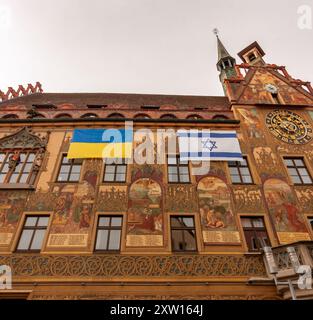 ULM, ALLEMAGNE - 18 FÉVRIER 2024 : bâtiment de l'hôtel de ville construit au XIVe siècle. Sur le mur, à l'appui, se trouvent les drapeaux de l'Ukraine et d'Israël Banque D'Images