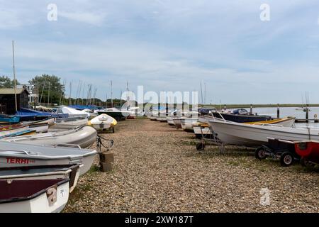 ORFORD, SUFFOLK, Royaume-Uni - 15 JUILLET 2024 : des bateaux sont arrêtés sur la plage au bord de la rivière ALDE Banque D'Images