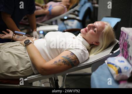 Odessa, Ukraine. 17 août 2024. Une femme donneuse avec un tatouage des armoiries de l'Ukraine sur son épaule est vue en train de donner du sang au Centre culturel de l'Union. En raison de l'agression militaire en cours de la Fédération de Russie, le don de sang est très important et extrêmement nécessaireTous ceux qui le souhaitaient, après examen et consultation avec un médecin, ont pu donner 450 ml de sang au Centre culturel de l'Union. Le projet a été organisé par DonorUA. Crédit : SOPA images Limited/Alamy Live News Banque D'Images