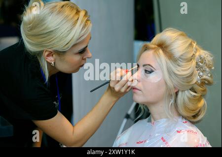 Femme maquilleuse faisant des sourcils avec la brosse à sourcils cosmétique sur le visage de la jeune femme cliente, salon de beauté. 6 novembre 2021. Kiev, Ukraine Banque D'Images