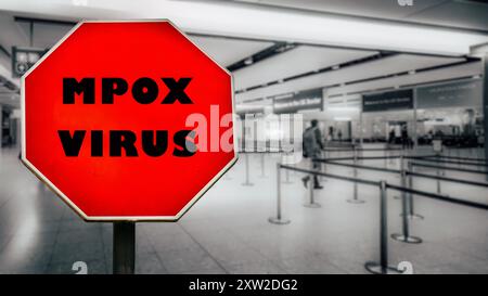 Un panneau d'arrêt rouge vif avertit les voyageurs de la présence du virus mpox dans un terminal d'aéroport, soulignant les risques pour la santé et les précautions à prendre. Banque D'Images