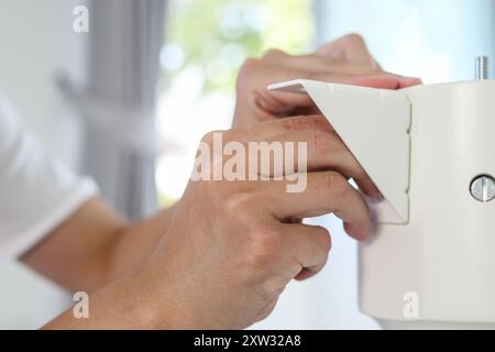 Homme asiatique assemblant des meubles de table blancs à la maison Banque D'Images