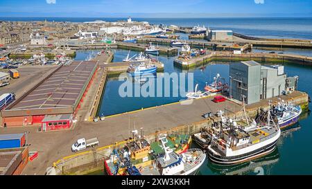 Port de Fraserburgh Aberdeenshire Écosse bassin de Faithlie et jetée le long bâtiment du marché aux poissons avec le phare de Kinnaird au loin Banque D'Images