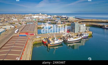 Port de Fraserburgh Aberdeenshire Écosse Faithlie Basin et jetée les longs bâtiments du marché aux poissons avec le phare de Kinnaird au loin Banque D'Images