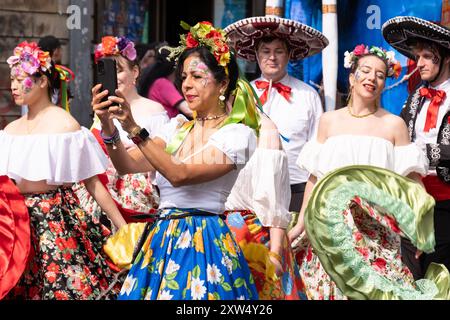 Belfast Mela Carnival Parade - belles dames vêtues de divers costumes appréciant la musique au début de l'événement. Belfast, Royaume-Uni - 17 août 2024. Banque D'Images