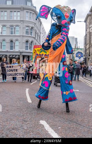 Belfast Mela Multicultural Carnival Parade - personne dans un costume décoratif élaboré d'éléphant bleu marchant sur pilotis. Belfast, Royaume-Uni - 17 août 2024. Banque D'Images