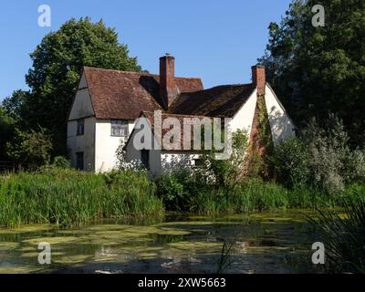 EAST BERGHOLT, SUFFOLK, Royaume-Uni - 29 JUILLET 2024 : vue extérieure de la maison de Willie Lott vue à travers l'étang du moulin Banque D'Images