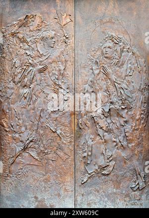 MILAN, ITALIE - 7 MARS 2024 : le moderne brozne relief de l'Annonciation sur la porte de l'église Chiesa di Santa Maria del Suffragio Banque D'Images