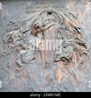 MILAN, ITALIE - 7 MARS 2024 : le moderne brozne relief de l'Assomption sur la porte de l'église Chiesa di Santa Maria del Suffragio Banque D'Images