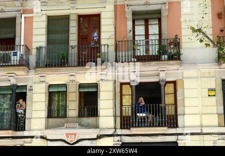 Les habitants sur leurs balcons regardant vers le bas au parc El Raval à Barcelone, Espagne. Banque D'Images