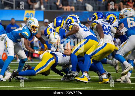 Los Angeles, Californie, États-Unis. 17 août 2024. Le quarterback Easton Stick #2 des Los Angeles Chargers dirige le ballon en luttant contre la pression des Rams de Los Angeles lors d'un match de pré-saison de football de la NFL au SoFi Stadium, le samedi 17 août 2024, à Inglewood, Calif. (crédit image : © Ringo Chiu/ZUMA Press Wire) USAGE ÉDITORIAL SEULEMENT! Non destiné à UN USAGE commercial ! Banque D'Images