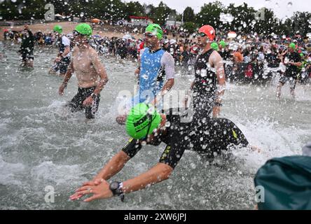 Langen, Allemagne. 18 août 2024. Triathlon : Championnat d'Europe, Ironman (3,86 km de natation, 180 km de vélo, 42, 195 km de course), hommes. Les athlètes du groupe d'âge commencent à Langener Waldsee pour la natation. Crédit : Arne Dedert/dpa/Alamy Live News crédit : dpa Picture alliance/Alamy Live News Banque D'Images
