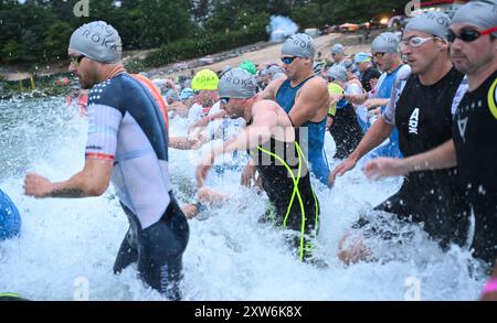 Langen, Allemagne. 18 août 2024. Triathlon : Championnat d'Europe, Ironman (3,86 km de natation, 180 km de vélo, 42, 195 km de course), hommes. Les pros sautent dans l'eau au départ de la baignade à Langener Waldsee. Crédit : Arne Dedert/dpa/Alamy Live News crédit : dpa Picture alliance/Alamy Live News Banque D'Images