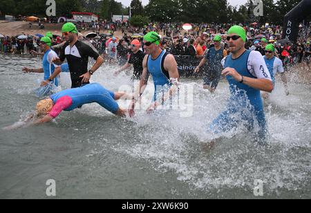 Langen, Allemagne. 18 août 2024. Triathlon : Championnat d'Europe, Ironman (3,86 km de natation, 180 km de vélo, 42, 195 km de course), hommes. Les athlètes du groupe d'âge commencent à Langener Waldsee pour la natation. Crédit : Arne Dedert/dpa/Alamy Live News crédit : dpa Picture alliance/Alamy Live News Banque D'Images