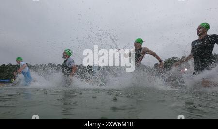 Langen, Allemagne. 18 août 2024. Triathlon : Championnat d'Europe, Ironman (3,86 km de natation, 180 km de vélo, 42, 195 km de course), hommes. Les athlètes du groupe d'âge commencent à Langener Waldsee pour la natation. Crédit : Arne Dedert/dpa/Alamy Live News crédit : dpa Picture alliance/Alamy Live News Banque D'Images
