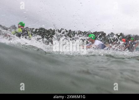 Langen, Allemagne. 18 août 2024. Triathlon : Championnat d'Europe, Ironman (3,86 km de natation, 180 km de vélo, 42, 195 km de course), hommes. Les athlètes du groupe d'âge commencent à Langener Waldsee pour la natation. Crédit : Arne Dedert/dpa/Alamy Live News crédit : dpa Picture alliance/Alamy Live News Banque D'Images