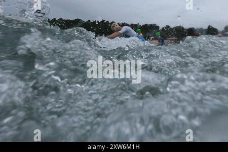 Langen, Allemagne. 18 août 2024. Triathlon : Championnat d'Europe, Ironman (3,86 km de natation, 180 km de vélo, 42, 195 km de course), hommes. Les athlètes du groupe d'âge commencent à Langener Waldsee pour la natation. Crédit : Arne Dedert/dpa/Alamy Live News crédit : dpa Picture alliance/Alamy Live News Banque D'Images