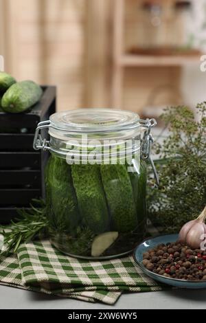 Concombres marinés en pot, herbes et épices sur la table, gros plan Banque D'Images